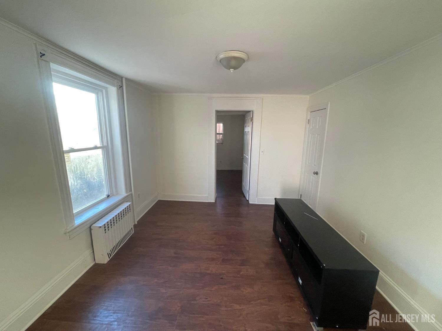577 Rahway Avenue Woodbridge, NJ 07095 - Photo 4 of 6 wooden floor in an empty room with a window