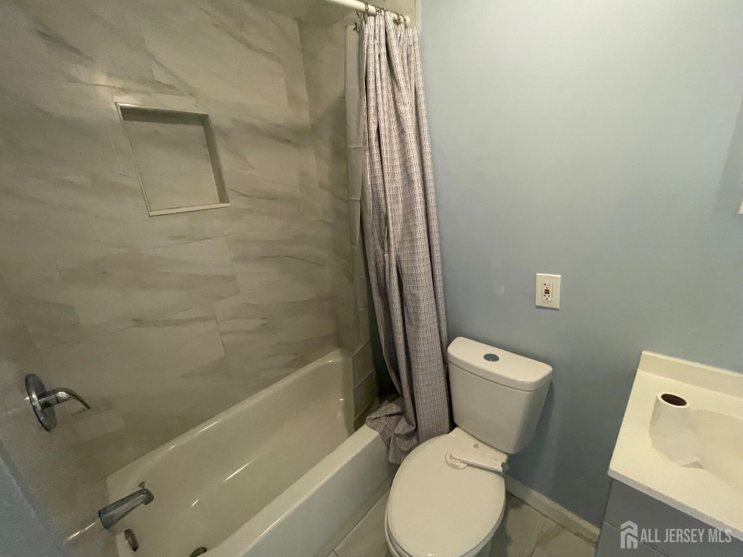 577 Rahway Avenue Woodbridge, NJ 07095 - Photo 5 of 6 a white toilet sitting next to a bath tub