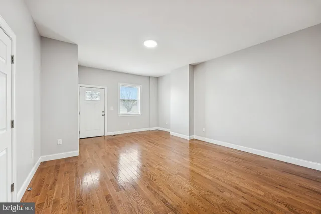 a kitchen with a refrigerator cabinets stainless steel appliances and a wooden floor