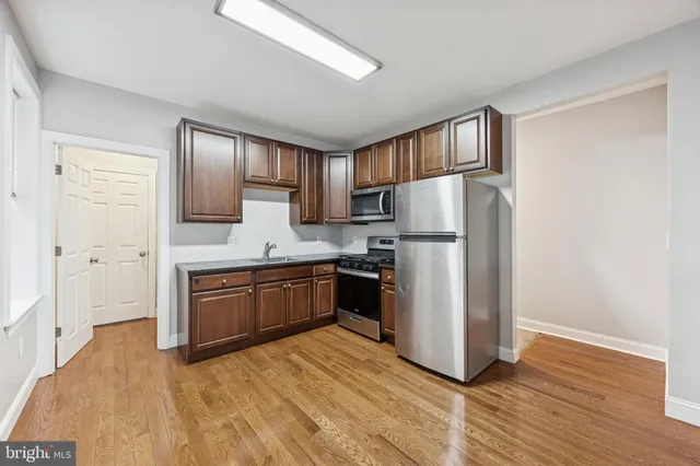 a kitchen with granite countertop a refrigerator stove and sink