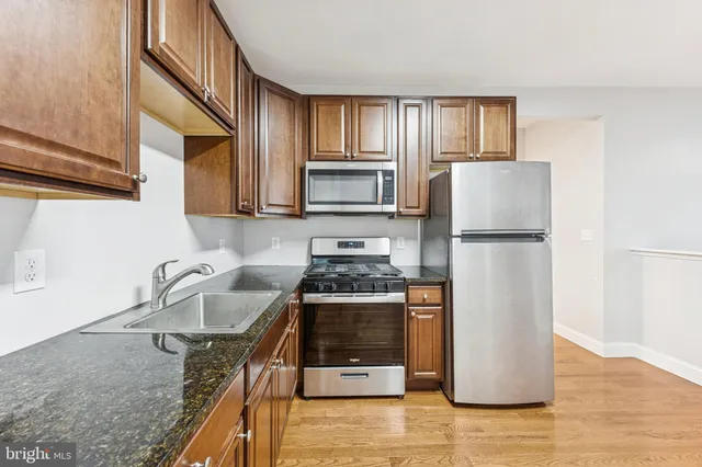 a kitchen with stainless steel appliances granite countertop a stove a sink and a refrigerator