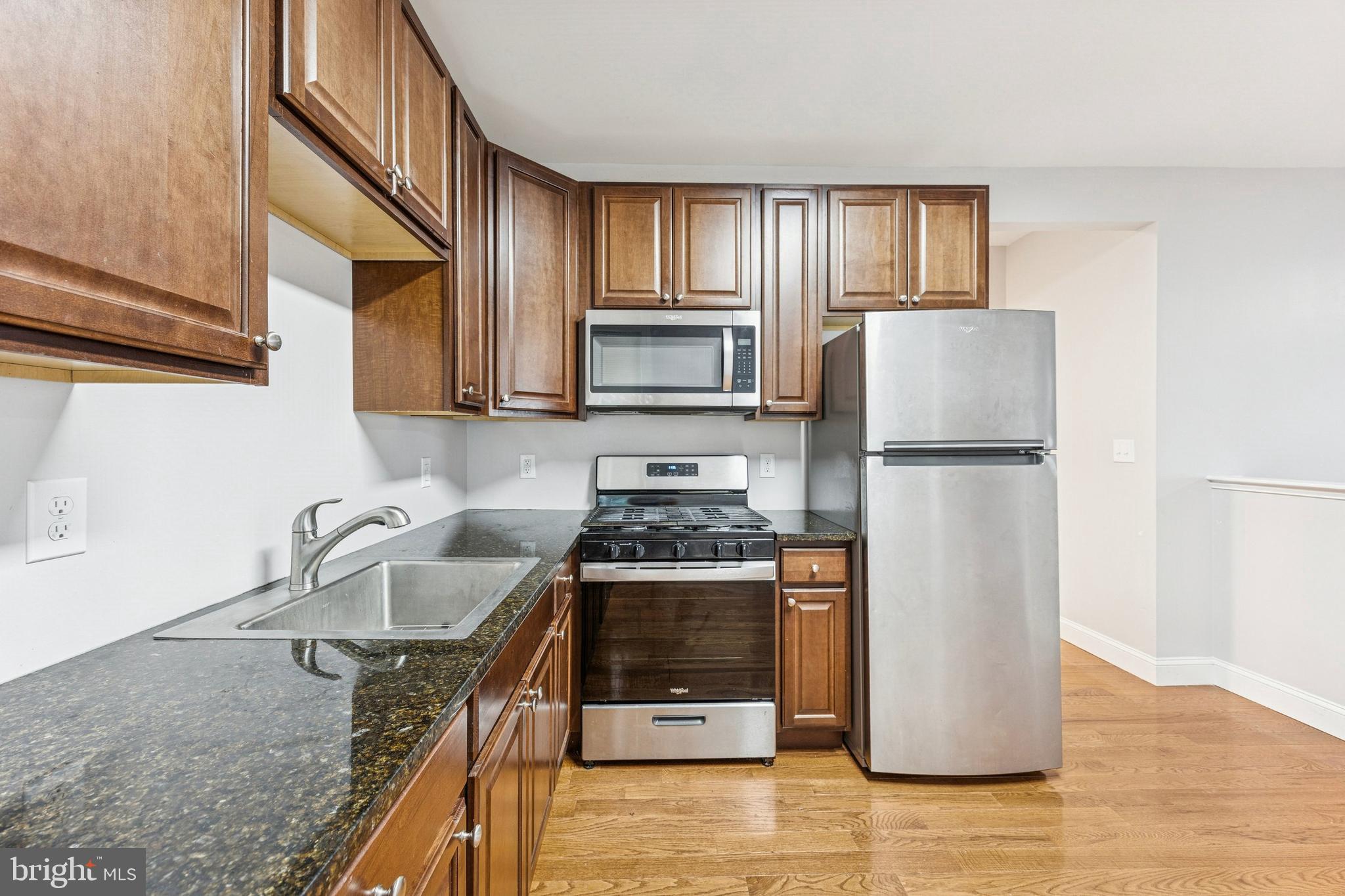 4602 Longshore Avenue Philadelphia, PA 19135 - Photo 7 of 16 a kitchen with granite countertop a refrigerator stove and sink