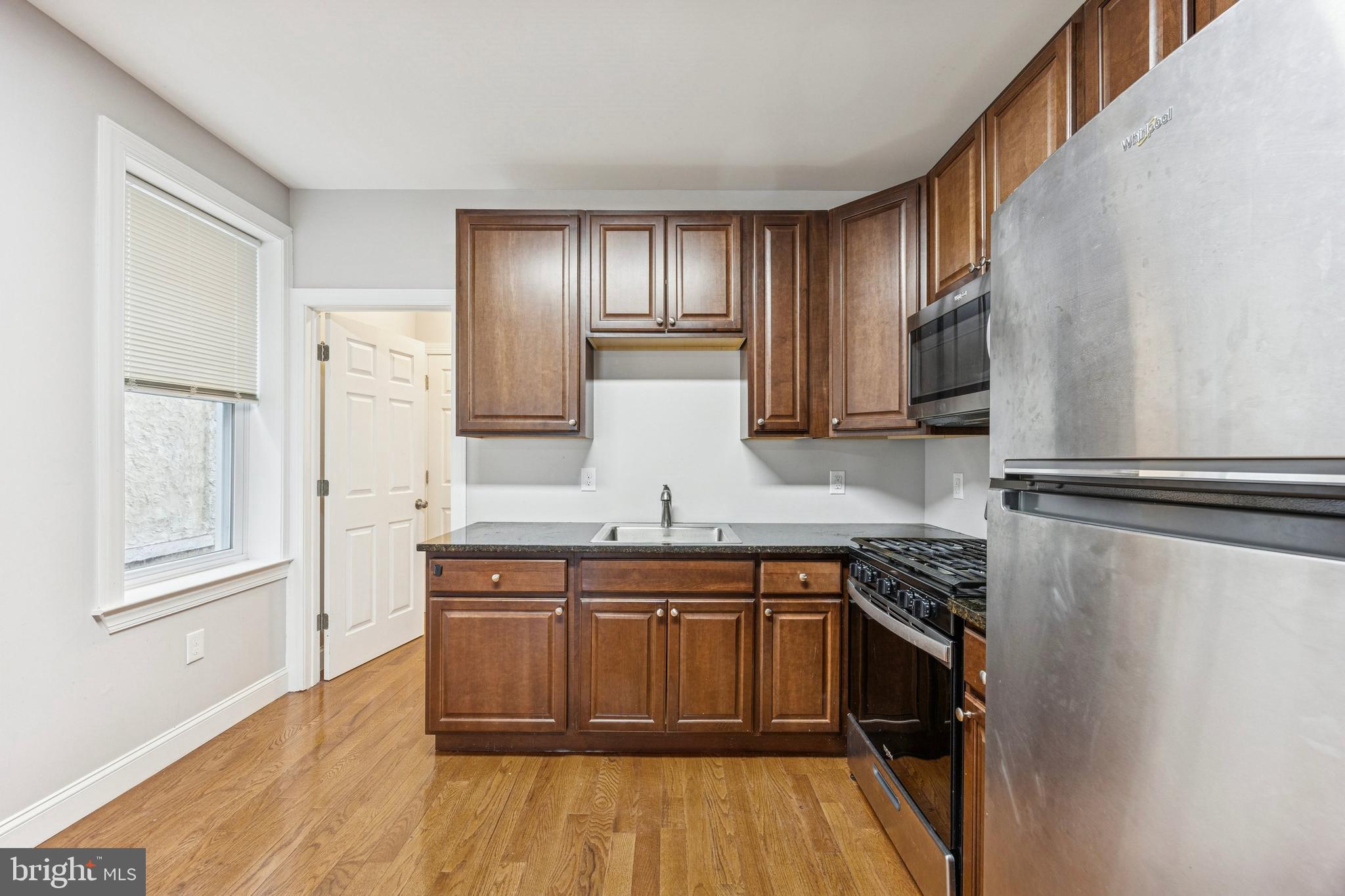 4602 Longshore Avenue Philadelphia, PA 19135 - Photo 8 of 16 a kitchen with stainless steel appliances granite countertop a stove a sink and a refrigerator