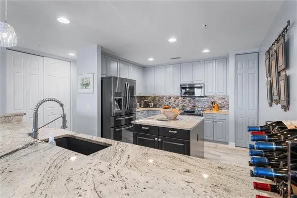 a bathroom with a toilet sink vanity granite and shower