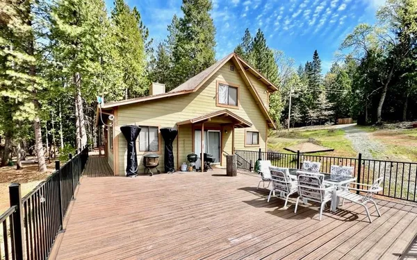a view of a roof deck with table and chairs under an umbrella with wooden floor