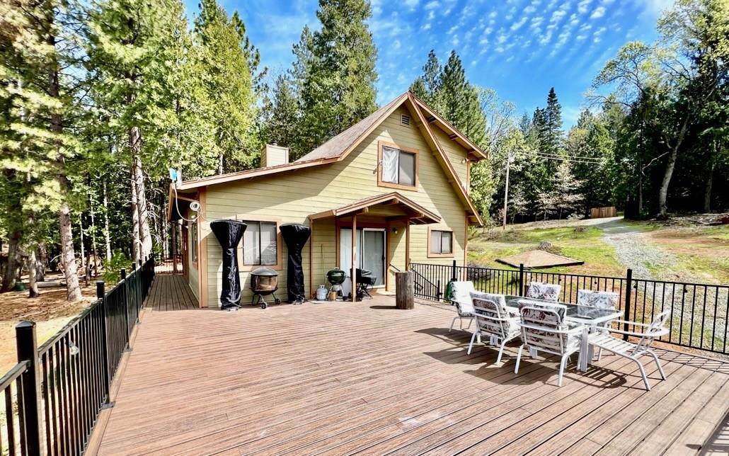 6330 Caldor Road Somerset, CA 95684 - Photo 1 of 30 a view of a roof deck with table and chairs under an umbrella with wooden floor