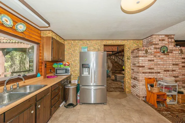 a kitchen with stainless steel appliances granite countertop a refrigerator and a sink