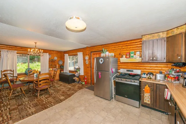 a kitchen with stainless steel appliances granite countertop a stove top oven a sink and dining table with granite countertops