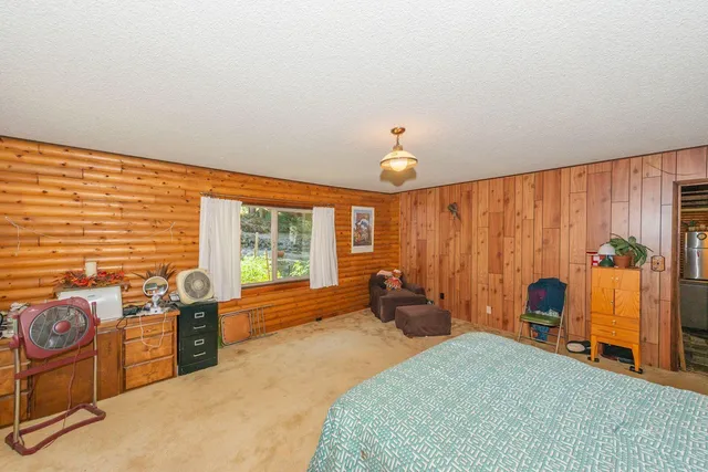a spacious bedroom with a bed and a chandelier