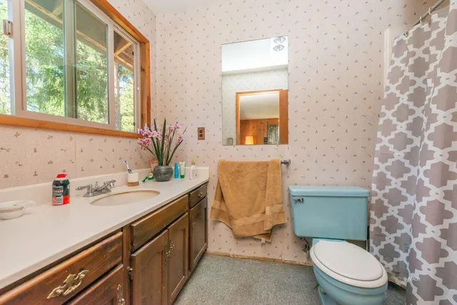 a bathroom with a granite countertop toilet sink and mirror
