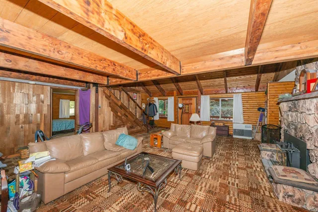 a living room with furniture a fireplace and a floor to ceiling window