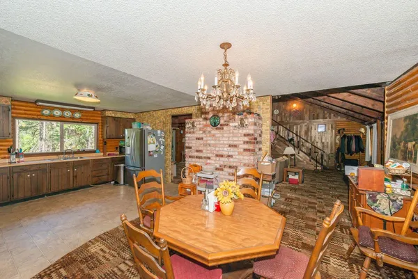 a dining room with furniture a chandelier and wooden floor