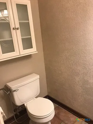 a white toilet sitting next to a small window