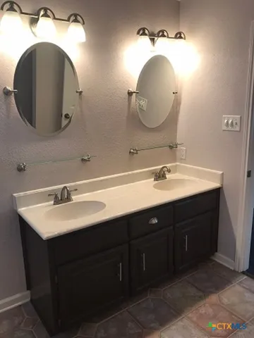 a bathroom with a double vanity sink and a mirror