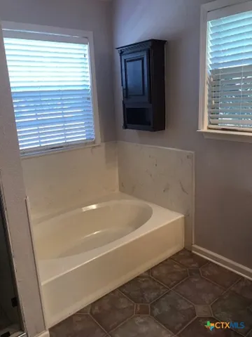 a bath tub sitting in a bathroom next to a window