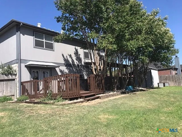 a view of a house with a yard and tree