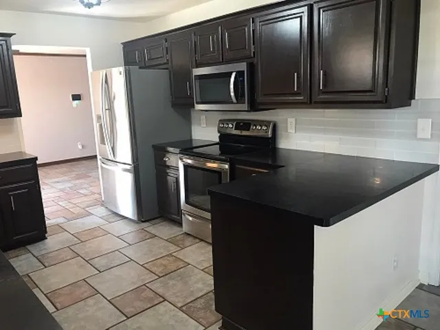 a kitchen with a refrigerator stove and microwave