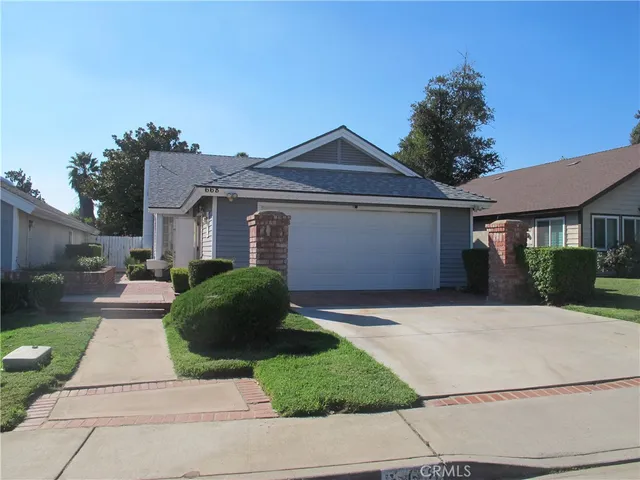 a front view of a house with a garden and plants