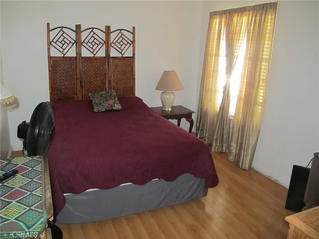 a bedroom with a bed and wooden floor