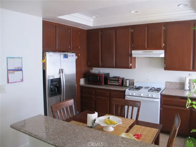 a kitchen with stainless steel appliances granite countertop a refrigerator a stove top oven a sink and dishwasher