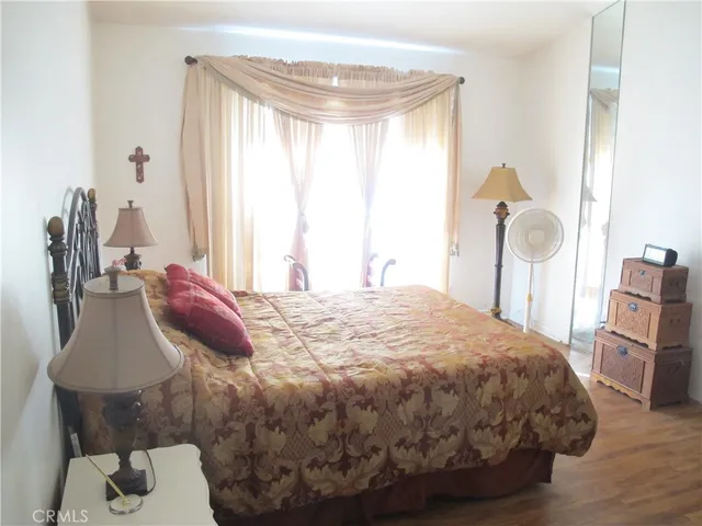 a large bed sitting in a bedroom next to a window