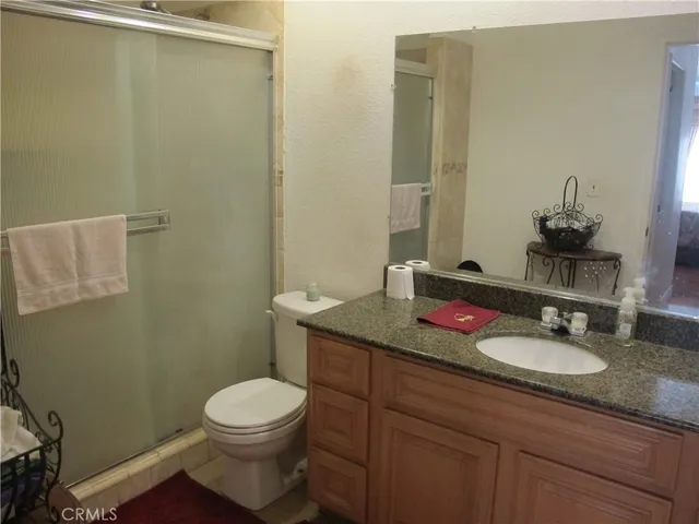 a bathroom with a granite countertop toilet sink and mirror