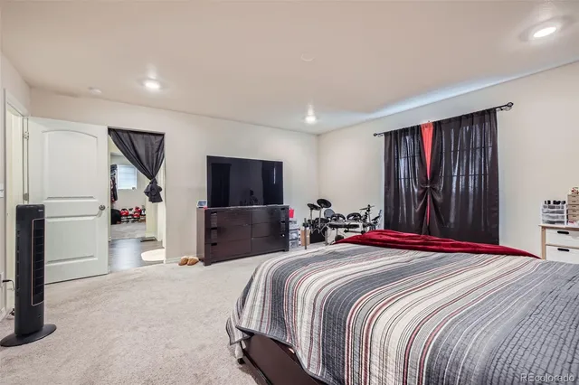 a bedroom with a large bed and a flat tv screen