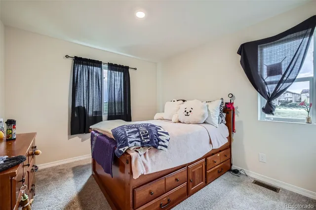a bed sitting in a bedroom next to a window