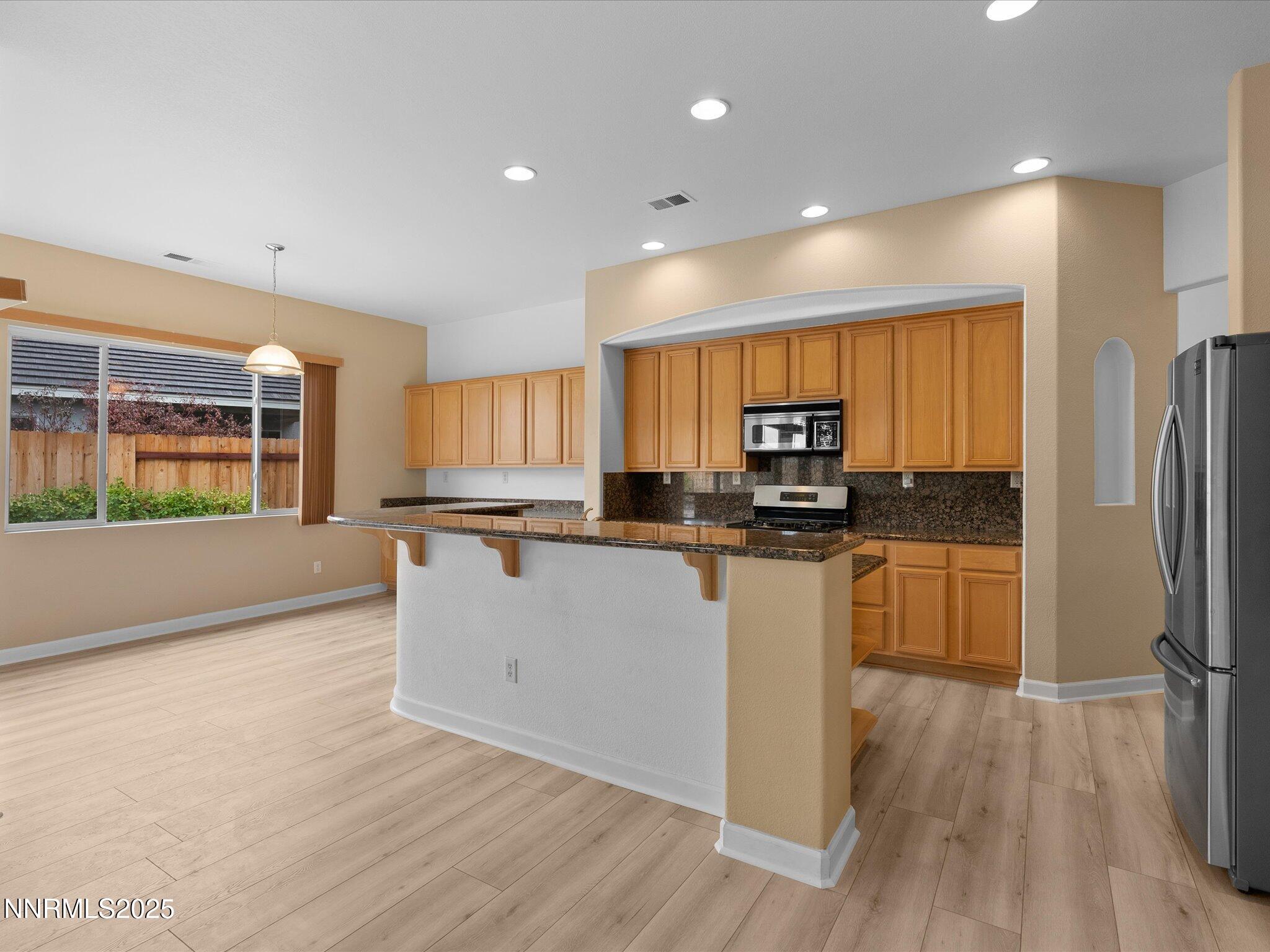10316 Sterling View Court Reno, NV 89521 - Photo 16 of 41 a kitchen with stainless steel appliances granite countertop a refrigerator a stove and a wooden floors
