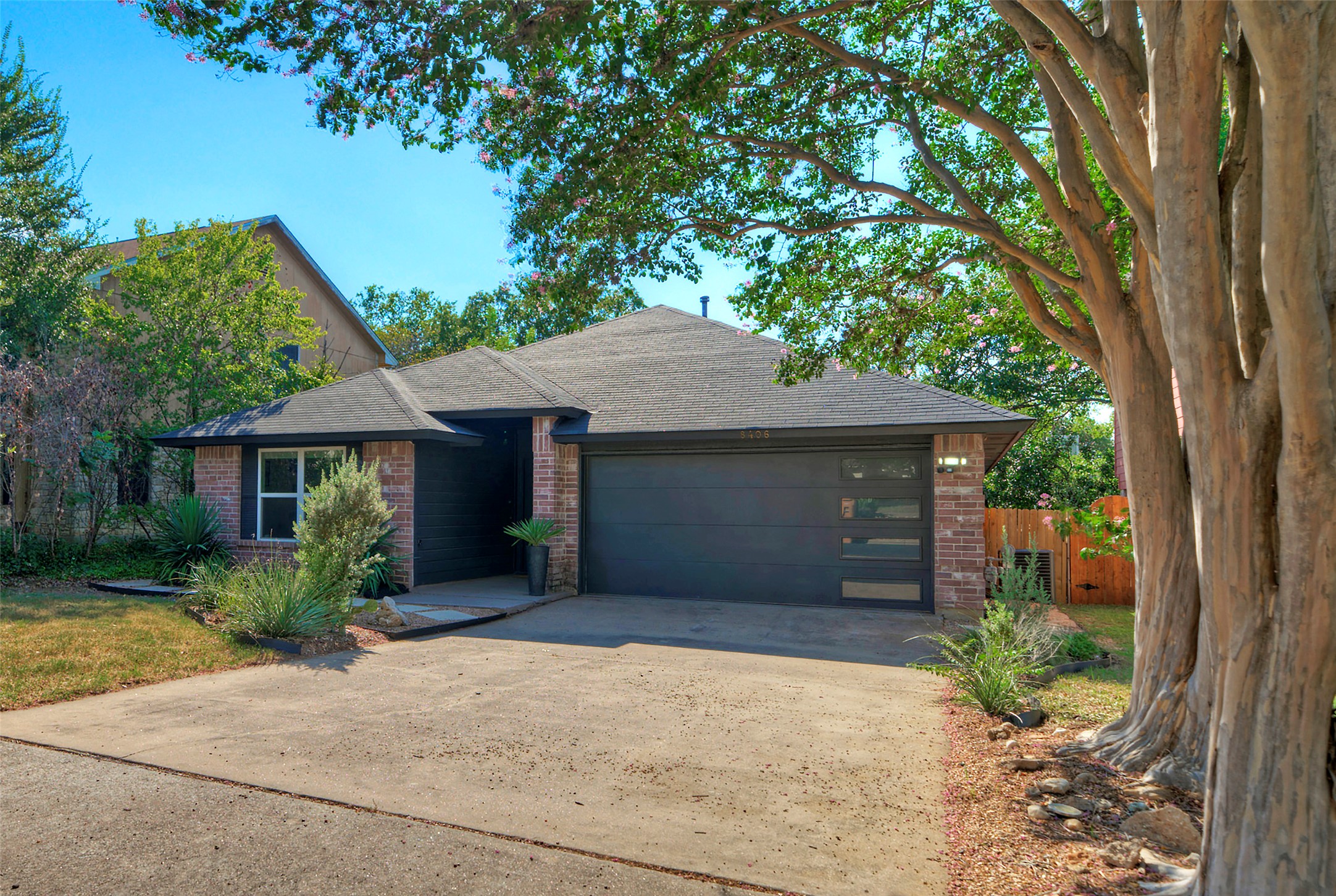 8406 Los Ranchos Drive Austin, TX 78749 - Photo 31 of 32 A classic brick exterior offers timeless curb appeal with lush, mature landscaping and a modern garage door.
