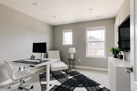 a living room with furniture a rug and white walls