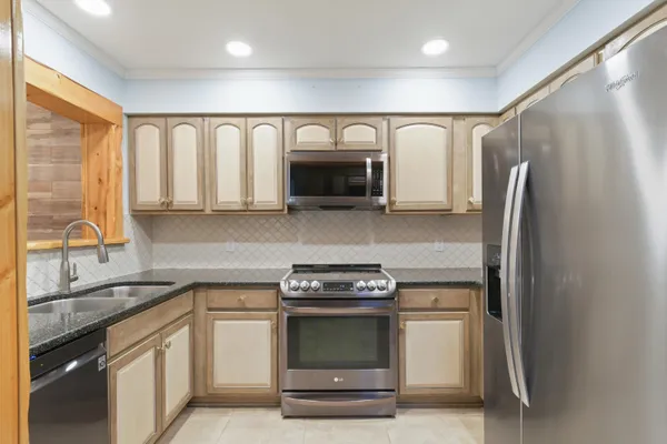 a kitchen with stainless steel appliances granite countertop a stove and a refrigerator