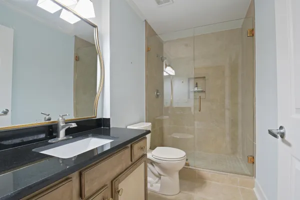 a bathroom with a granite countertop sink toilet and shower