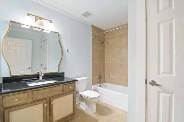a bathroom with a granite countertop sink toilet a large mirror a vanity and shower