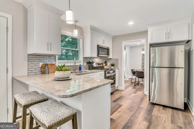 a kitchen with stainless steel appliances granite countertop a sink refrigerator and microwave