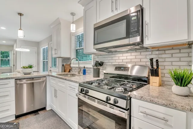 a kitchen with granite countertop stainless steel appliances and white cabinets