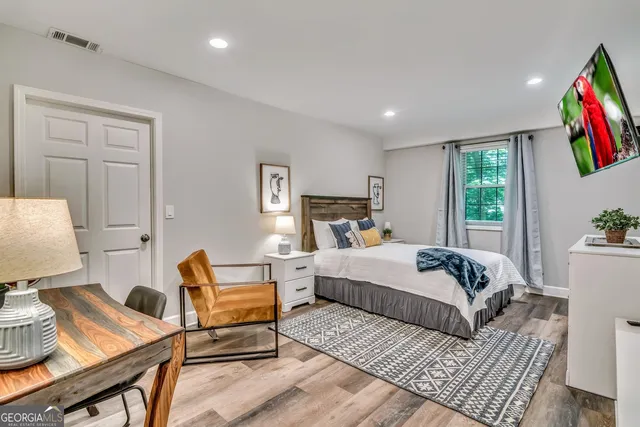 a bedroom with a bed and wooden floor