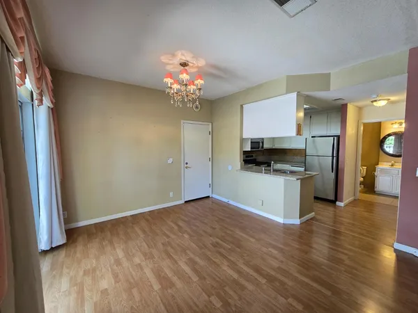 a view of kitchen with granite countertop stainless steel appliances and wooden floor