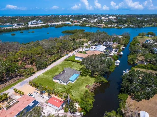 an aerial view of ocean and residential houses with outdoor space