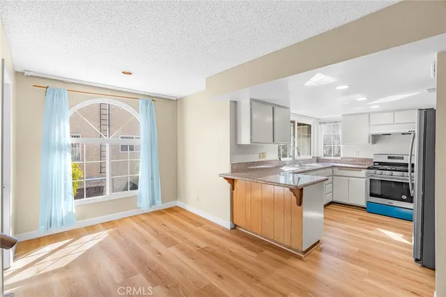 a kitchen with stainless steel appliances granite countertop a stove a sink and a refrigerator