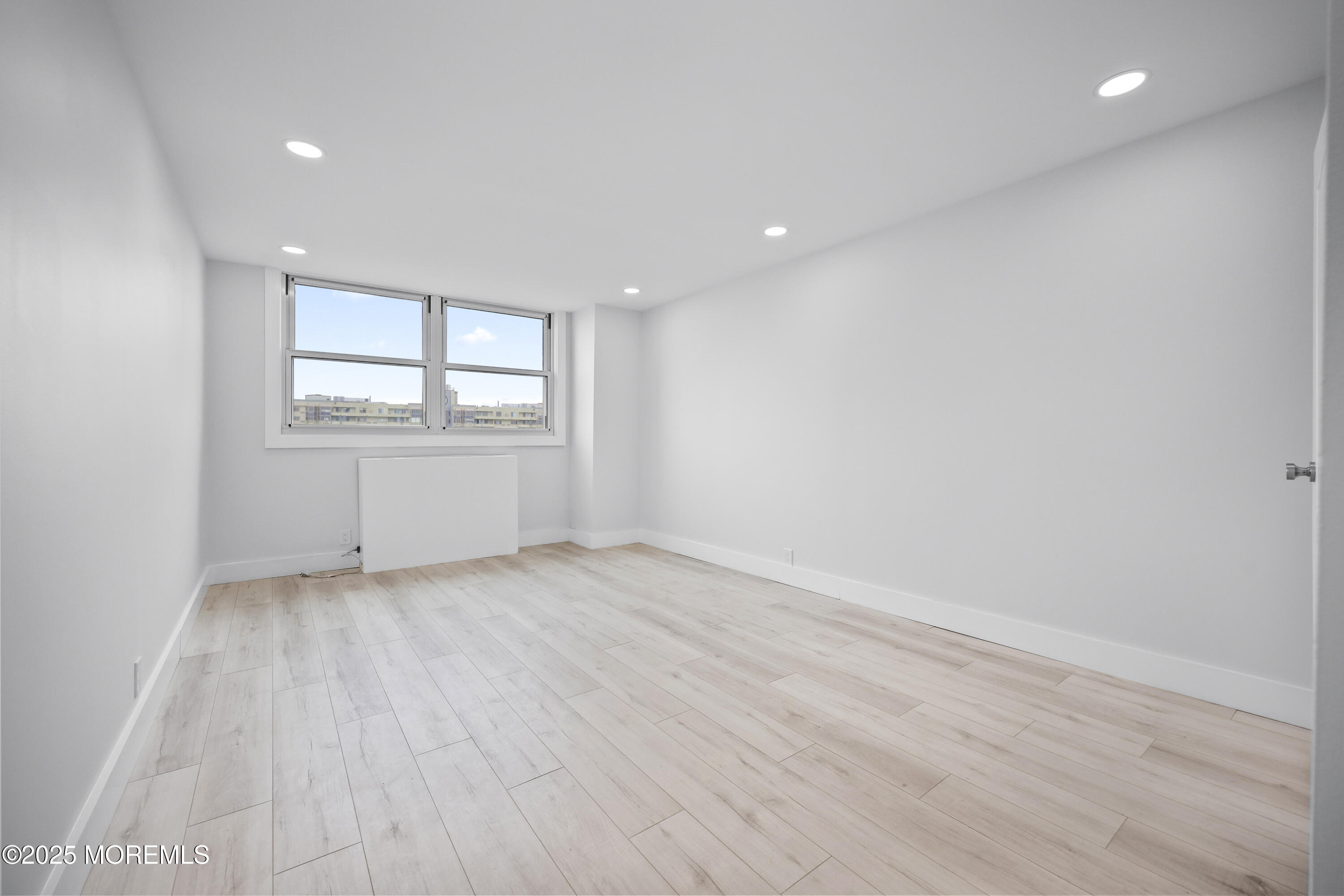 675 Ocean Avenue, Unit 9F Long Branch, NJ 07740 - Photo 14 of 31 an empty room with wooden floor and windows