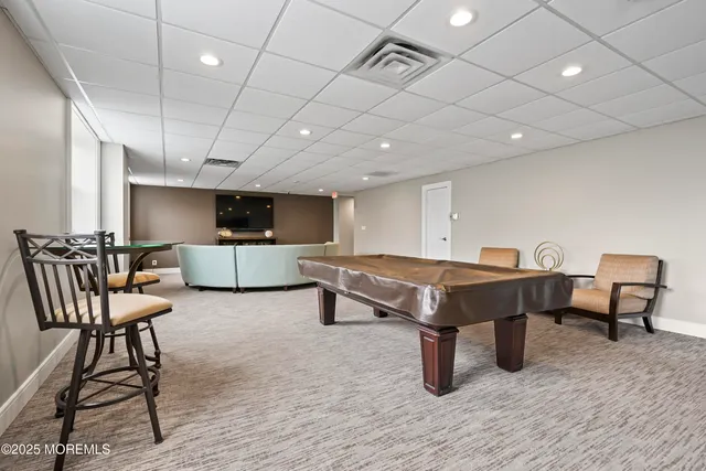 a kitchen with stainless steel appliances granite countertop a table chairs and a refrigerator