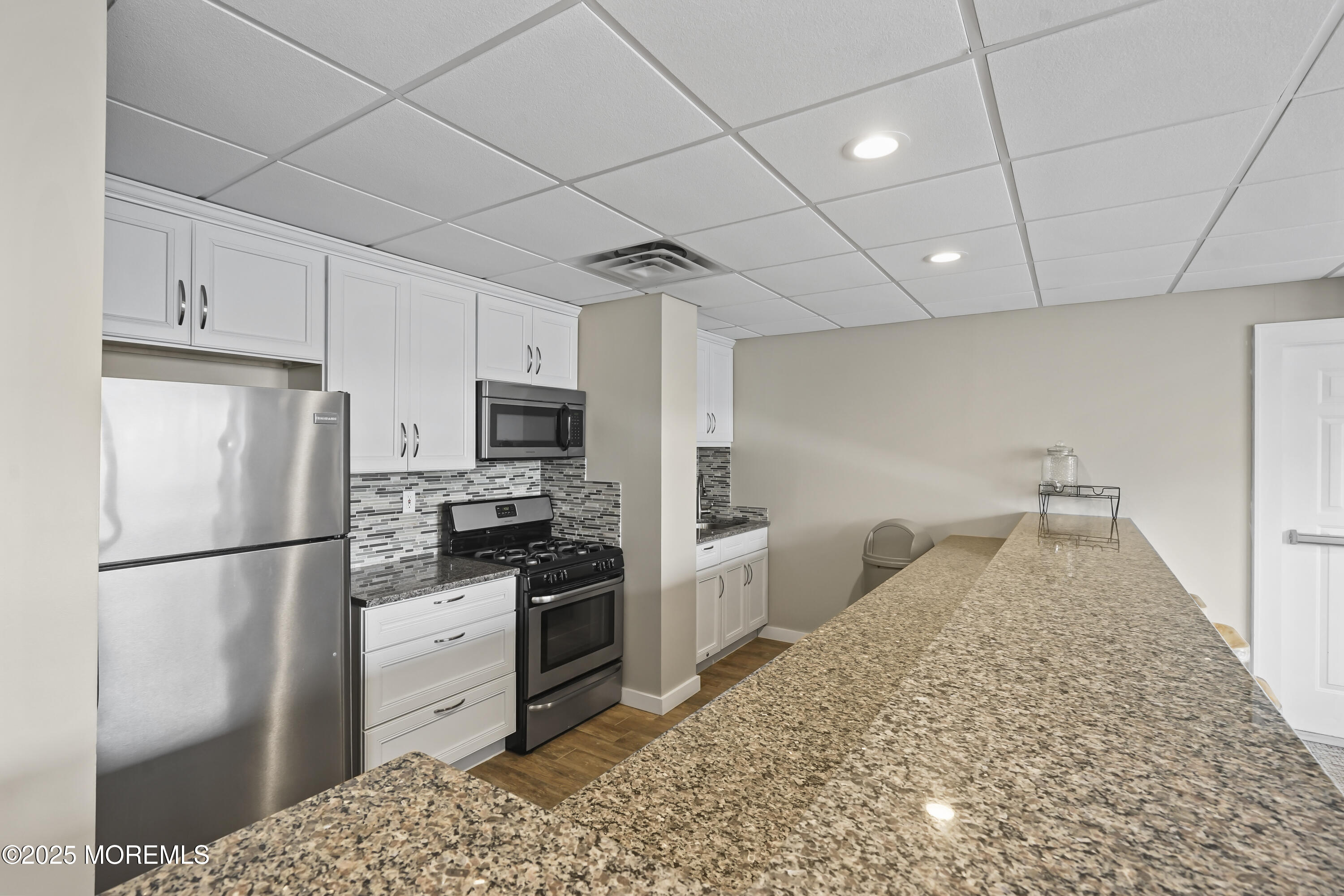 675 Ocean Avenue, Unit 9F Long Branch, NJ 07740 - Photo 28 of 31 a kitchen with stainless steel appliances granite countertop a refrigerator a stove a sink and a refrigerator