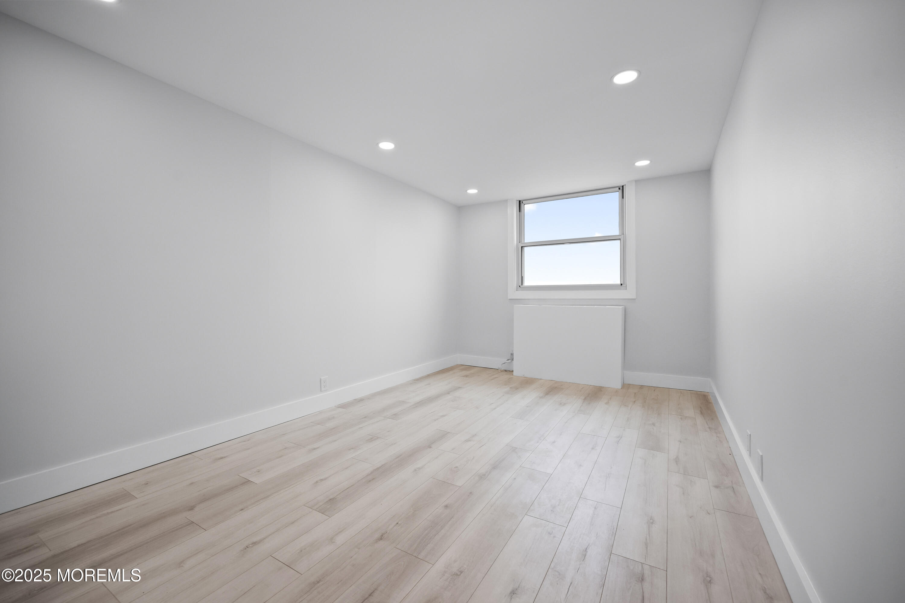 675 Ocean Avenue, Unit 9F Long Branch, NJ 07740 - Photo 30 of 31 an empty room with wooden floor and windows