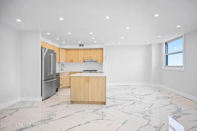 a view of an empty room with a cabinet and a kitchen