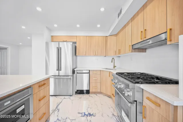 a large white kitchen with kitchen island granite countertop a large counter top and appliances