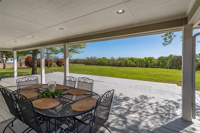 a view of a house with wooden deck and furniture