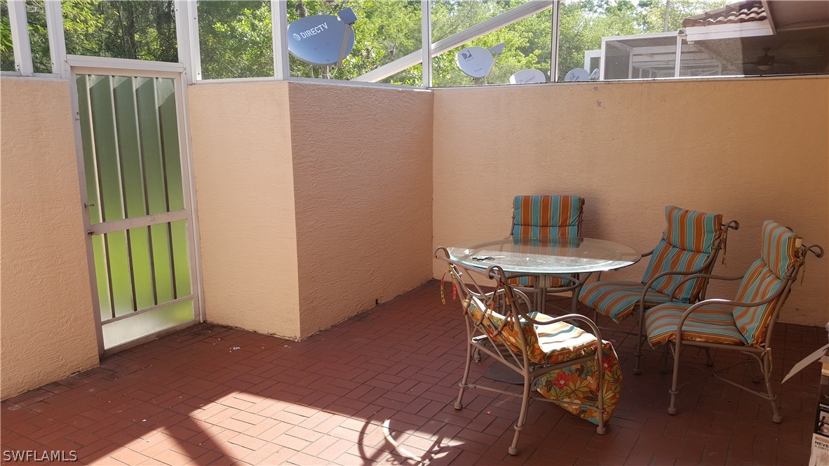 3829 Schoolhouse Road East, Unit 3 Fort Myers, FL 33916 - Photo 16 of 18 a view of a chairs and table in the backyard