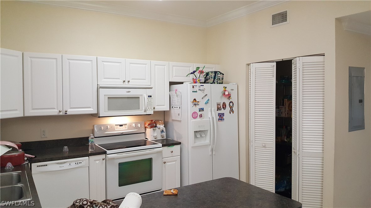 3829 Schoolhouse Road East, Unit 3 Fort Myers, FL 33916 - Photo 4 of 18 a kitchen with stainless steel appliances a refrigerator a stove and white cabinets