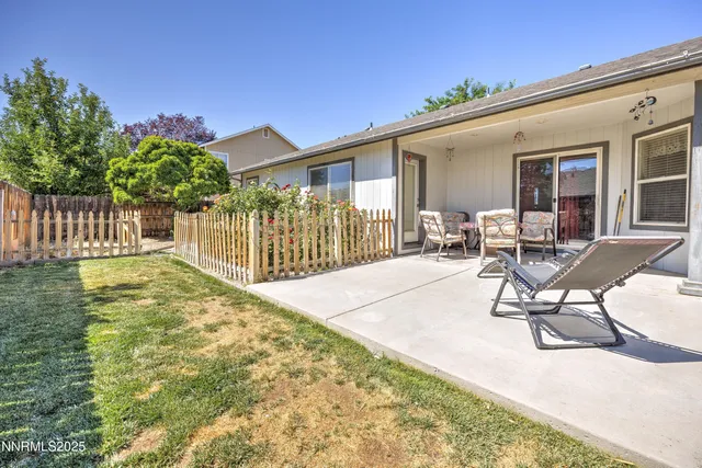 a view of a house with backyard and sitting area